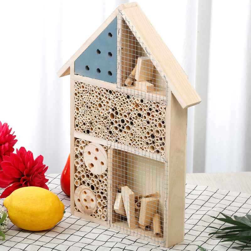 Schmales Insektenhaus aus Holz mit Bambusröhren und Drahtgitter als Nisthilfe für Wildbienen und Nützlinge