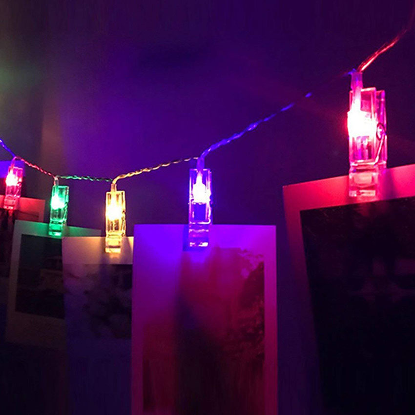 Wunderschöne Präsentation der Foto Lichterkette LED mit warmem Licht und Bildern im Wohnzimmer, ideal für ein hyggeliges Ambiente.