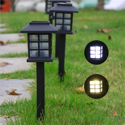 Solarbodenleuchte mit klarem Weiss-LED zwischen Pflanzen und Gartenwegen am Sommerabend