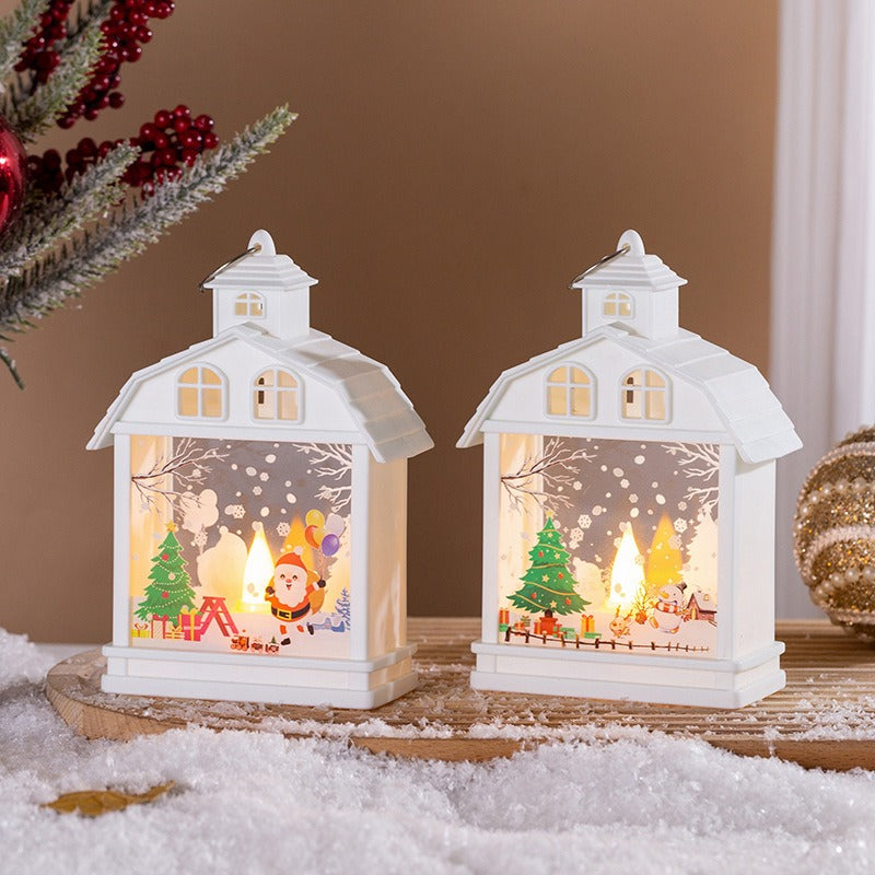 Zwei weisse Weihnachtslaternen mit Weihnachtsmann und Tannenbaum auf Kunstschnee