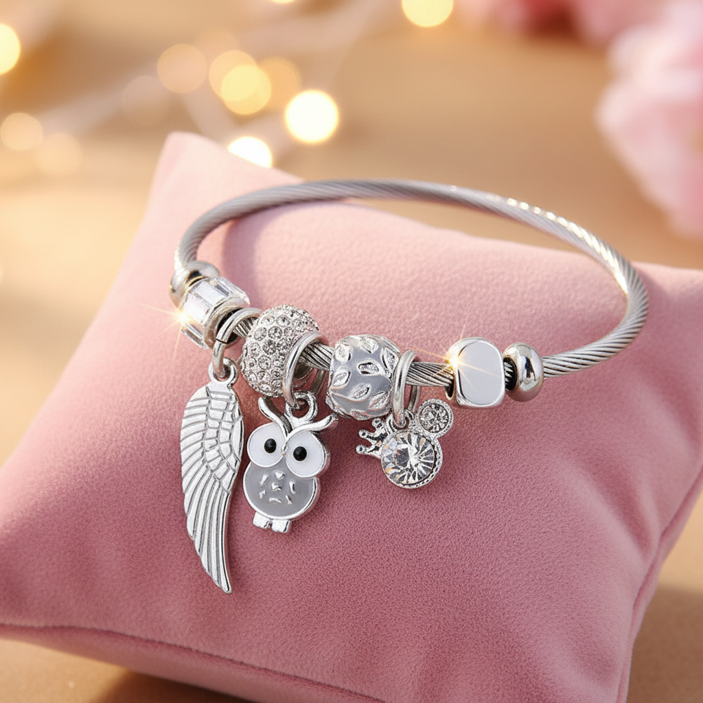 Charm Armband Engelsflügel Grau, symbolisiert mit Engelsflügeln, Eule und Kristallen Bedeutung und Eleganz.