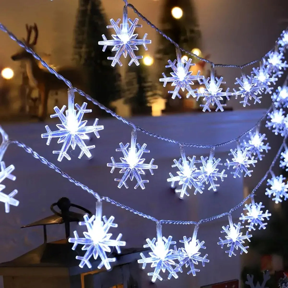 Kaltweisse LED Schneeflocken Lichterkette über einem Kaminsims mit Winterdeko