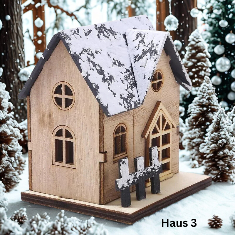 LED-Holzhaus Haus 3 mit Dachgaube und verschneitem Zaun zwischen Tannen