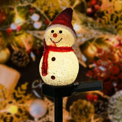 Schneemann mit roter Mütze und Schal leuchtet warmweiss vor Tannenschmuck
