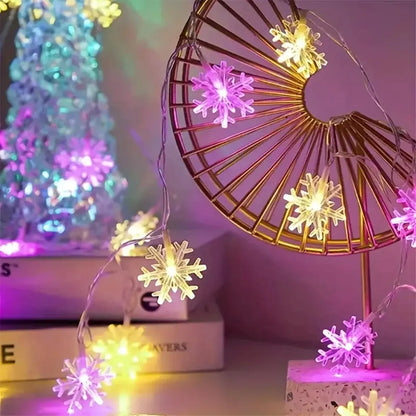 Rosa und bunt leuchtende Schneeflocken Lichterkette an einem goldenen Deko-Fächer