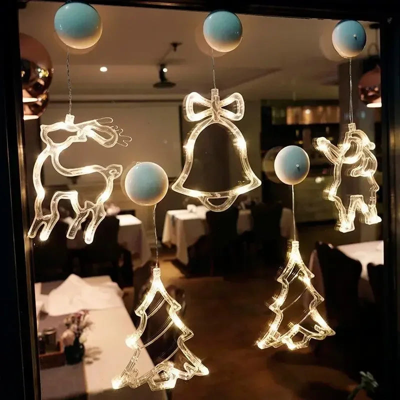 LED Fensterlichter Rentier, Glocke und Tannenbaum an einer Glasscheibe