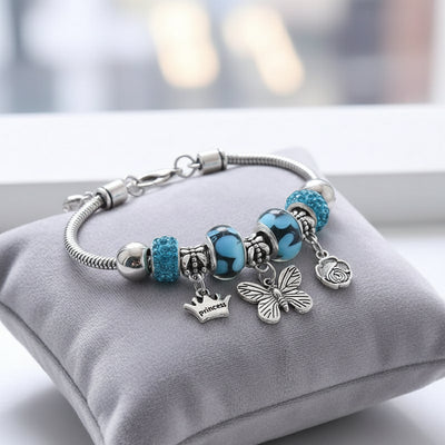 Charm-Armband in Saphir-Blau mit Schmetterling, Krone und Rose