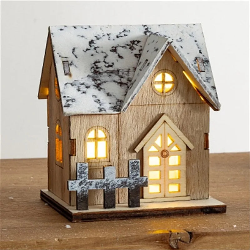 Holzhaus mit Dachgaube und warmweiss leuchtender Türe auf Holztisch