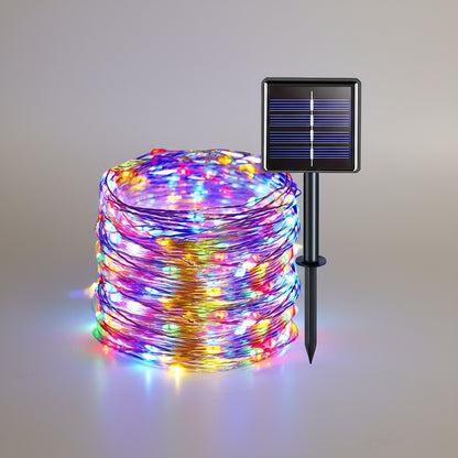 Bunte Solar Lichterkette aufgerollt mit Solarmodul auf Erdspiess