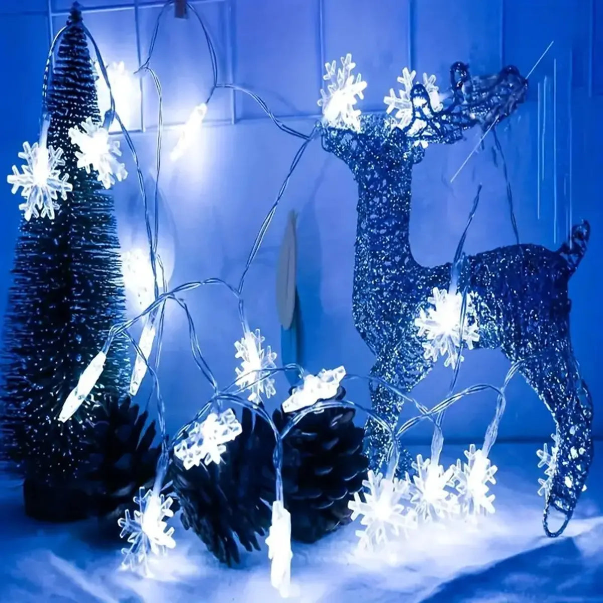 Kaltweisse Schneeflocken Lichterkette mit glitzerndem Deko-Rentier und Tannenzapfen