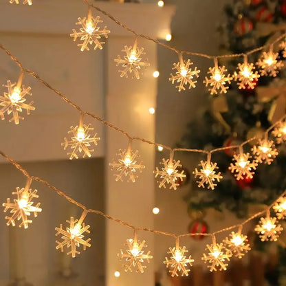 Warmweisse Schneeflocken Lichterkette vor einem geschmückten Weihnachtsbaum