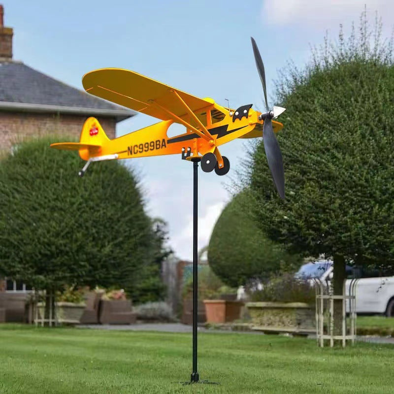 Metall Flugzeug Windrad gelb im Garten – Windspiel auf Stab vor Haus und Hecken