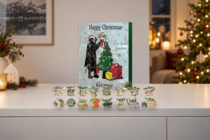 Baby-Yoda-Adventskalender mit Grogu-Figuren auf weissem Sideboard, Christbaum mit Lichtern im Hintergrund
