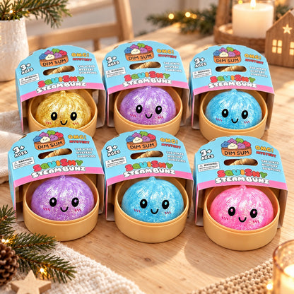 Sechs Glitzer Dumpling Squishies in Dampfkörbchen mit Banderole auf dem Holztisch