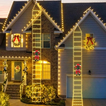 Zwei warmweiss leuchtende Weihnachtsmann Leitern an einer Hausfassade am Abend
