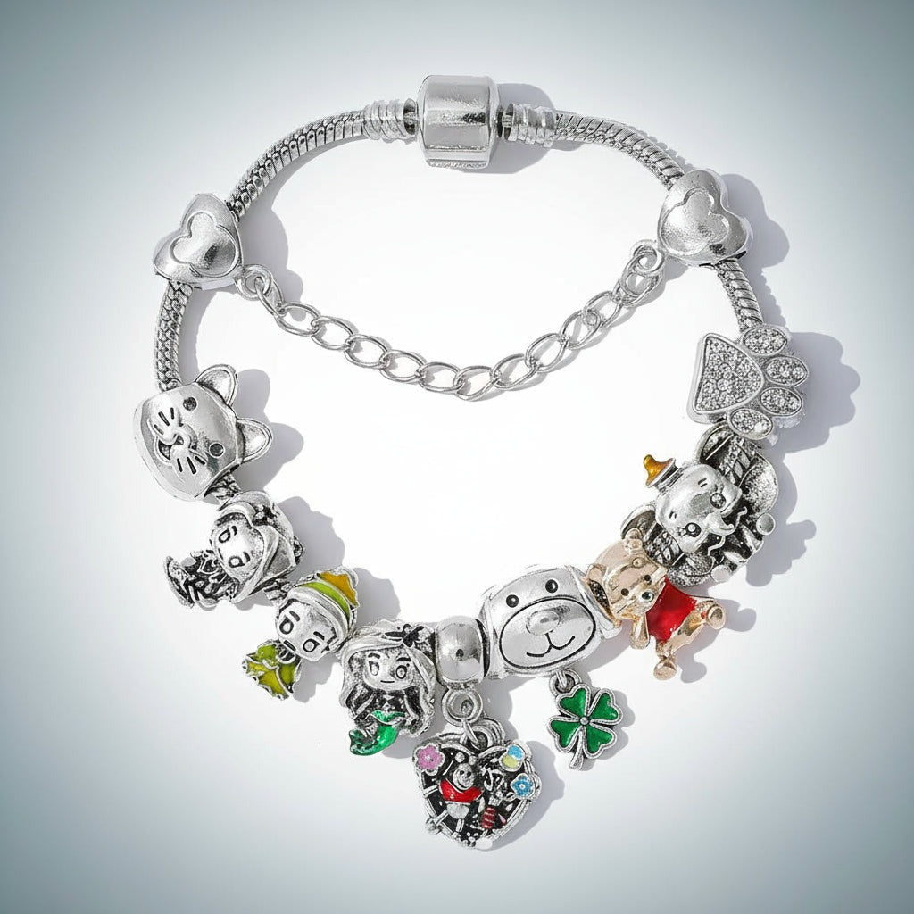 Nahaufnahme vom silberfarbenen Schlangenarmband mit Pooh-Charm, Pfote mit Glitzersteinchen und Sicherheitskette